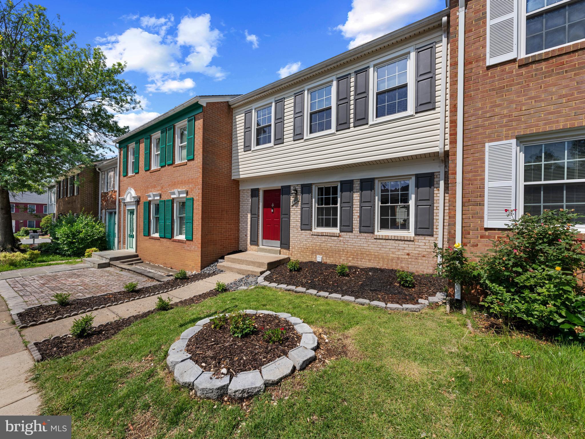 8448 Kitchener Drive Springfield, VA 22153 - Photo 2 of 32 a view of a brick house with a yard potted plants and large tree