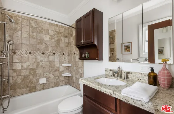 a bathroom with a granite countertop sink toilet and shower