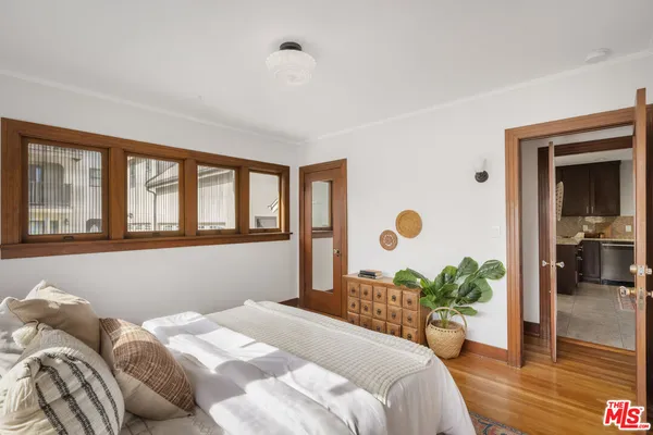 a bedroom with a bed mirror and a large window