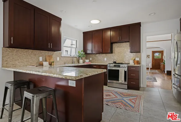 a kitchen with stainless steel appliances granite countertop wooden cabinets a stove top oven a sink and dishwasher