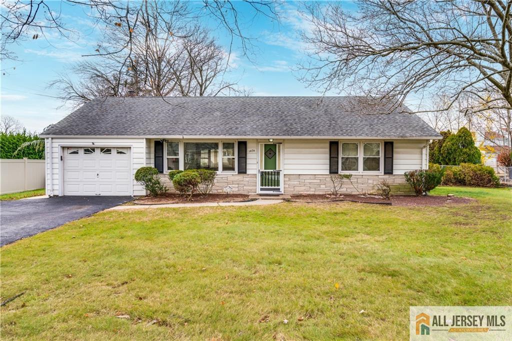 a front view of house with yard and trees in the background