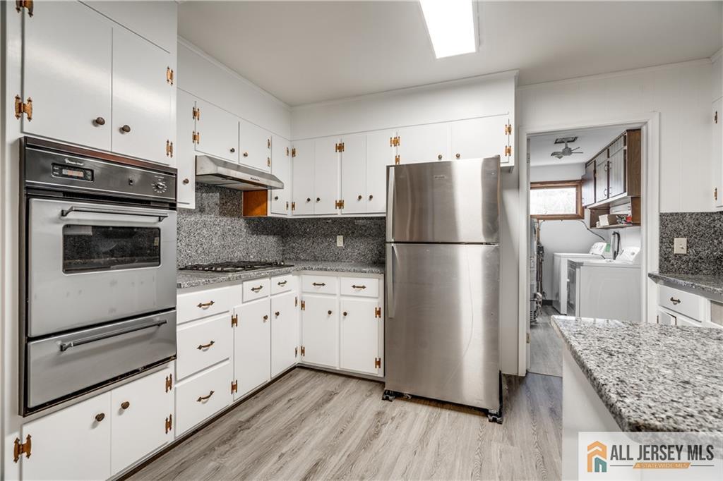 1474 Huron Road North Brunswick, NJ 08902 - Photo 6 of 16 a kitchen with granite countertop white cabinets and stainless steel appliances