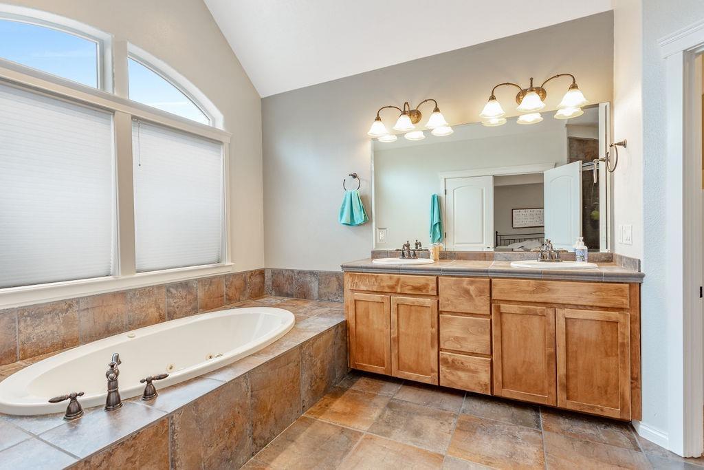 1042 Pumpkin Ridge Eagle Point, OR 97524 - Photo 21 of 34 a spacious bathroom with a granite countertop sink and a mirror