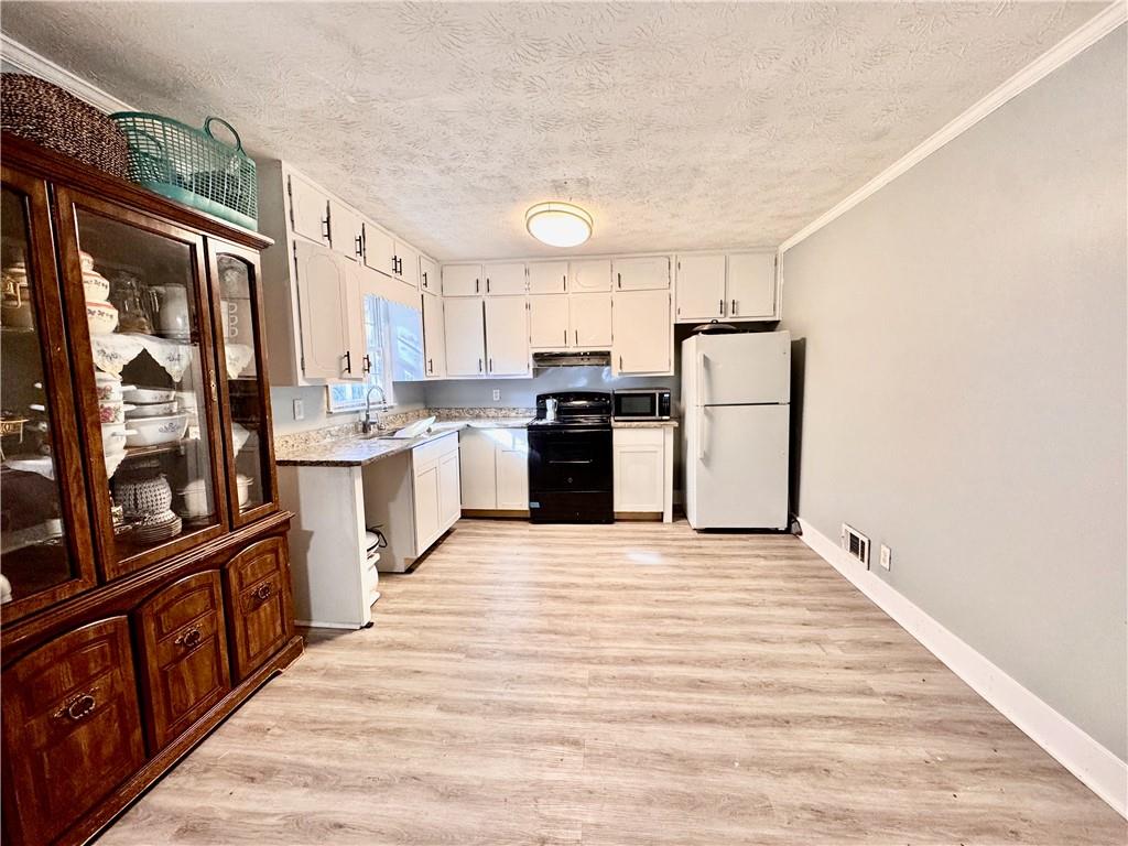 1825 North Road Snellville, GA 30078 - Photo 7 of 43 a large kitchen with stainless steel appliances granite countertop a refrigerator oven a sink dishwasher and white cabinets with wooden floor