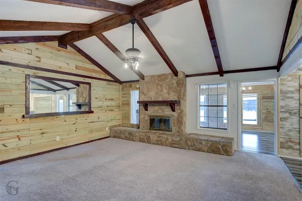 a view of an empty room with a fireplace and wooden floor