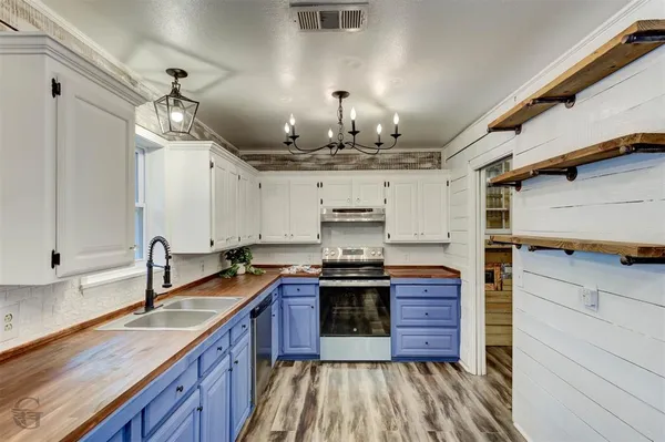 a kitchen with kitchen island granite countertop a sink and wooden cabinets