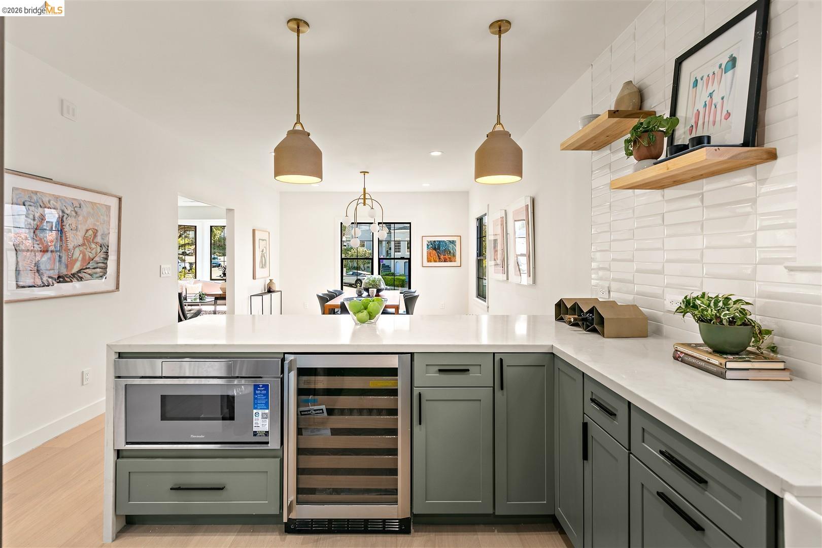 1668 Arch Street Berkeley, CA 94709 - Photo 21 of 78 Kitchen island with integrated microwave and beverage refrigerator, white countertops, green cabinetry, and a textured white tile backsplash