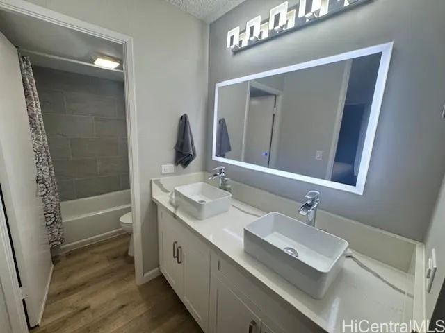a bathroom with a double vanity sink a mirror and a bathtub