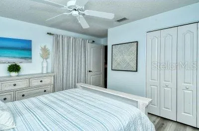 a bedroom with a bed and a closet with mirror on dresser