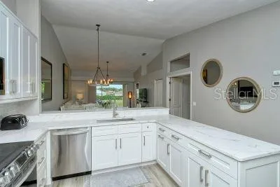 a kitchen with kitchen island granite countertop white cabinets and a sink