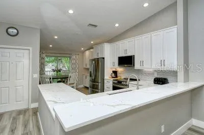a kitchen with stainless steel appliances granite countertop a sink a stove and a refrigerator