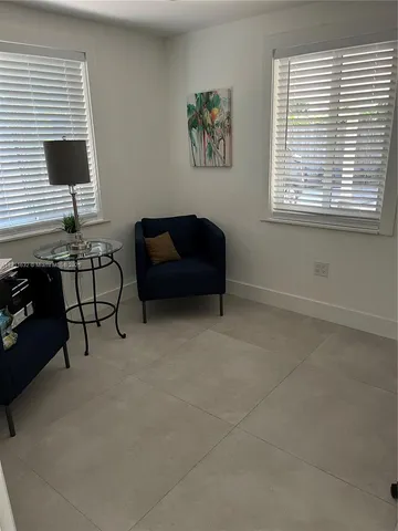 a living room with furniture a rug and a wall painting