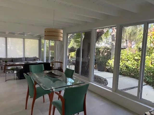 a dining room with furniture a chandelier and wooden floor