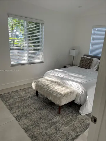 a bed sitting in a bedroom next to a window