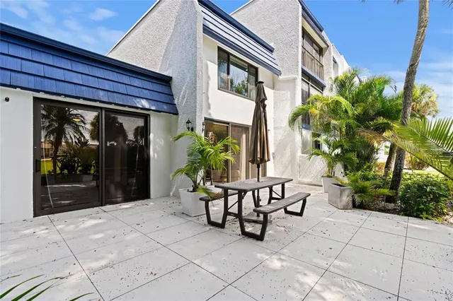 a view of patio with a table and chairs and potted plants
