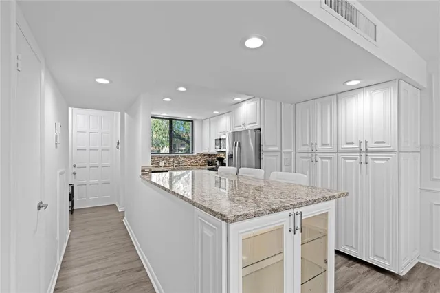 a kitchen with stainless steel appliances granite countertop a refrigerator and a sink