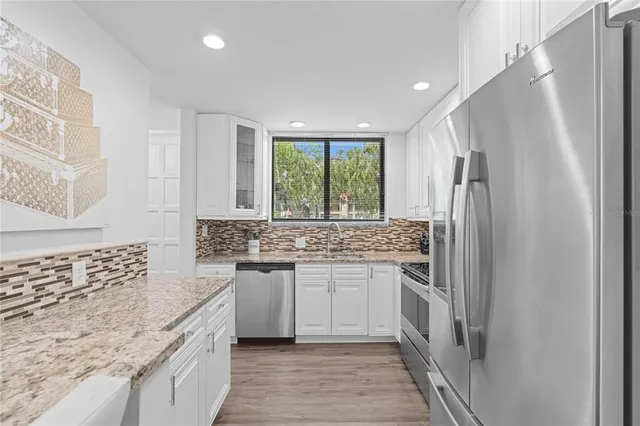 a kitchen with stainless steel appliances granite countertop a refrigerator and a sink