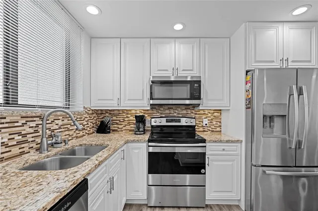 a kitchen with appliances a sink and cabinets
