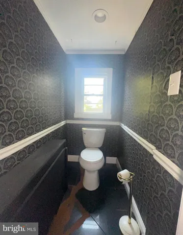 a bathroom with a toilet a sink and mirror