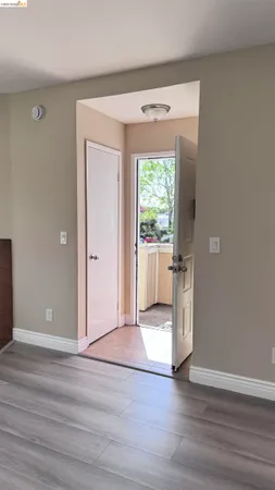a view of a hallway with wooden floor and a cabinet