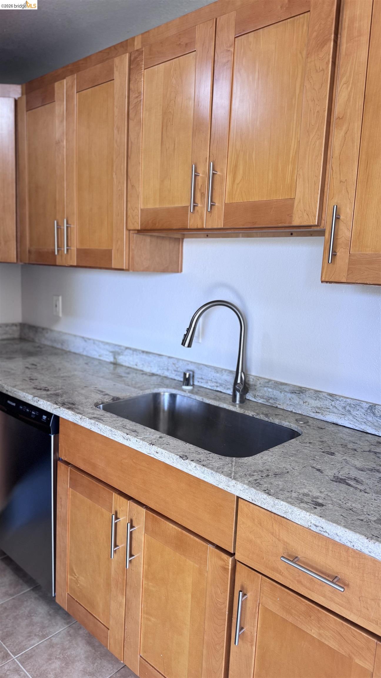 23 Raintree Court, Unit 15 Hayward, CA 94544 - Photo 13 of 16 Kitchen featuring light stone countertops, dishwasher, and wood finish cabinetry