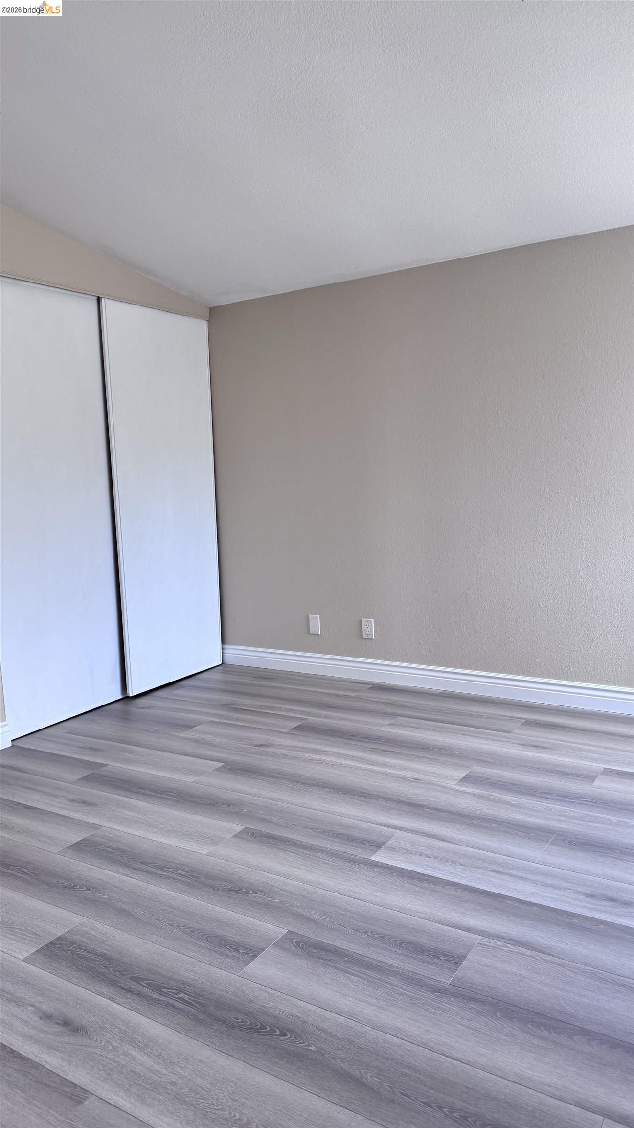 23 Raintree Court, Unit 15 Hayward, CA 94544 - Photo 6 of 16 Unfurnished bedroom with a closet and light wood-type flooring