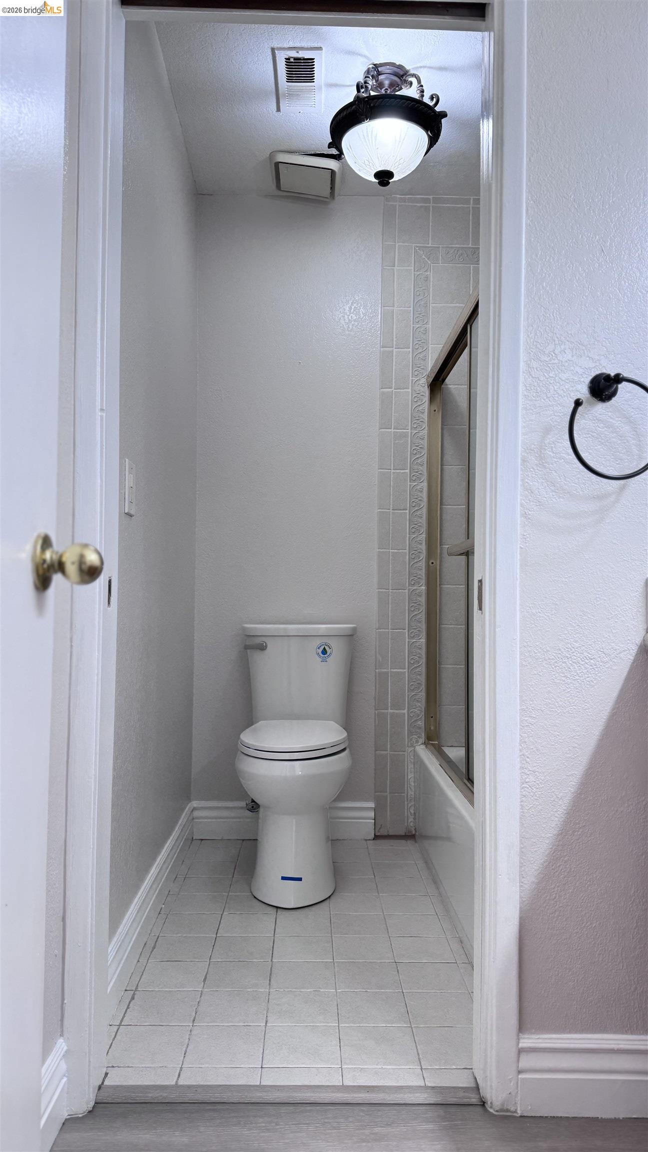 23 Raintree Court, Unit 15 Hayward, CA 94544 - Photo 7 of 16 Full bathroom featuring a textured wall, light tile patterned floors, and enclosed tub / shower combo
