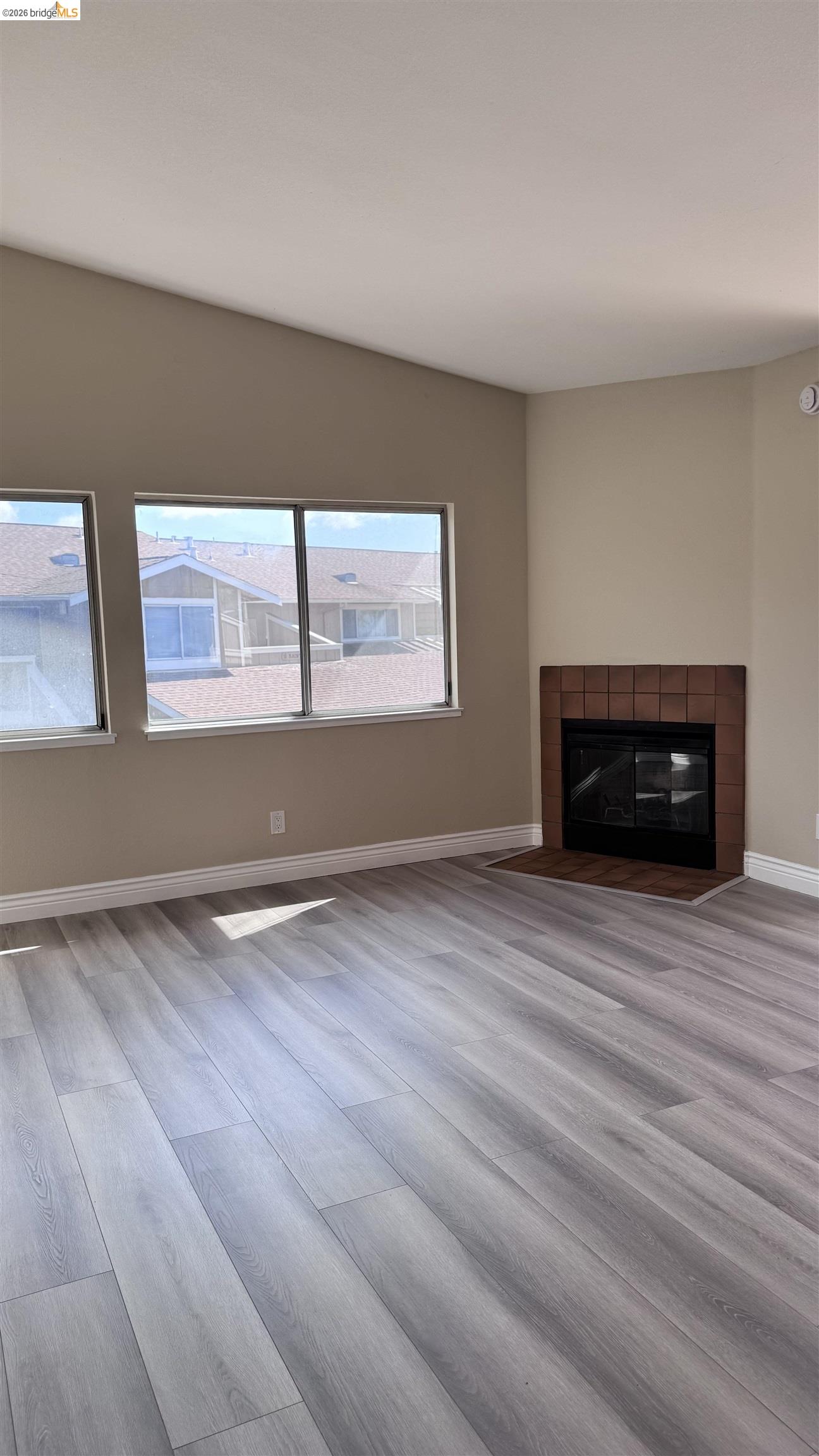 23 Raintree Court, Unit 15 Hayward, CA 94544 - Photo 10 of 16 Unfurnished living room featuring a tiled fireplace and light wood finished floors
