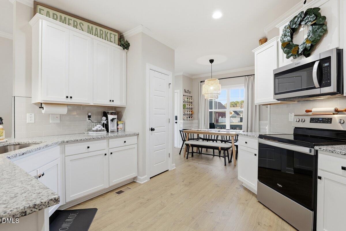 110 Oak Street Pine Level, NC 27568 - Photo 11 of 30 a kitchen with stainless steel appliances white cabinets sink and stove