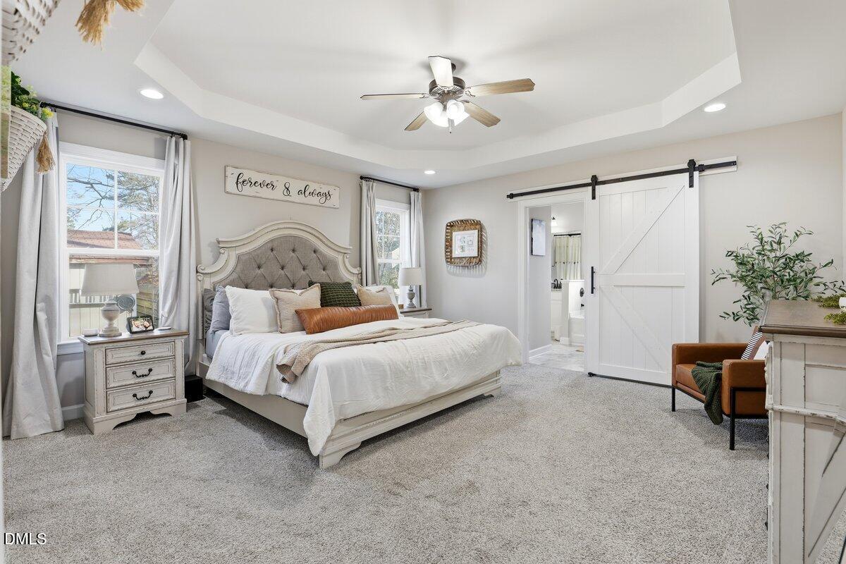 110 Oak Street Pine Level, NC 27568 - Photo 16 of 30 a bedroom with a bed and a chandelier