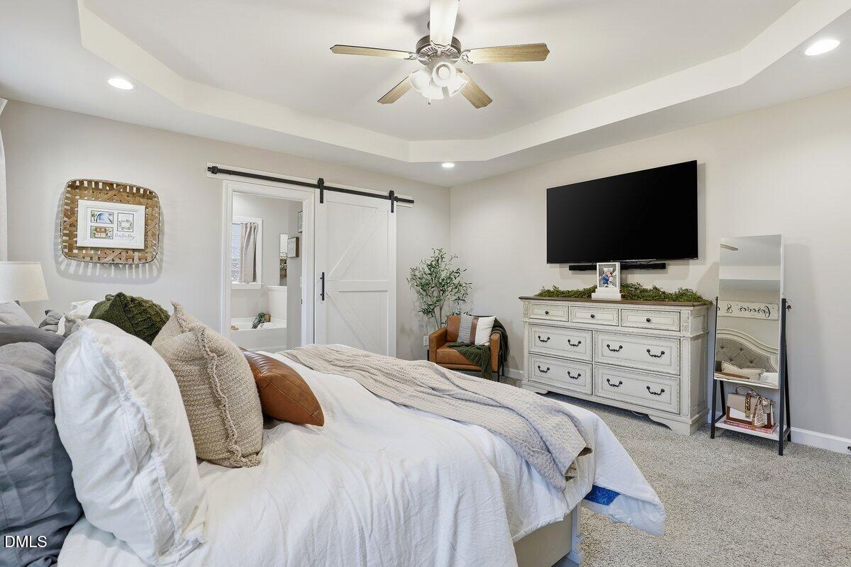 110 Oak Street Pine Level, NC 27568 - Photo 17 of 30 a bedroom with a bed and a flat screen tv