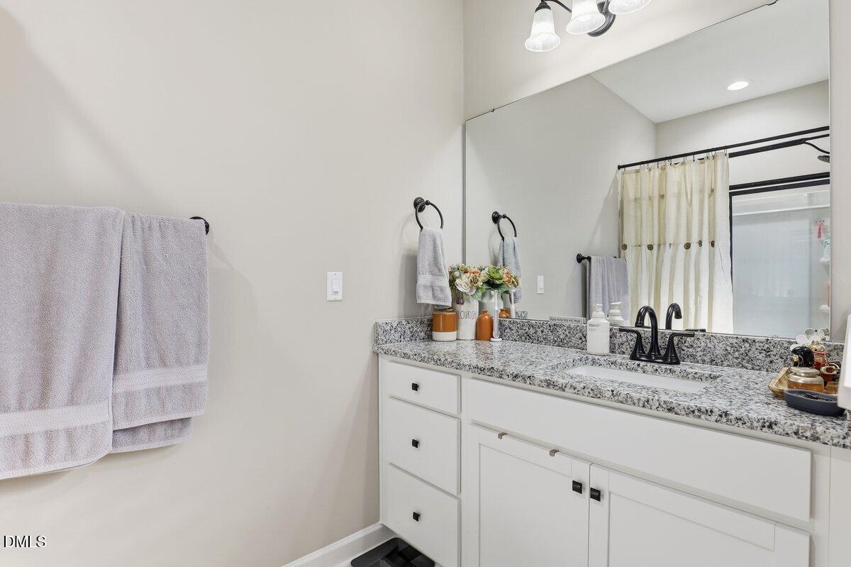 110 Oak Street Pine Level, NC 27568 - Photo 21 of 30 a bathroom with a granite countertop sink and a mirror