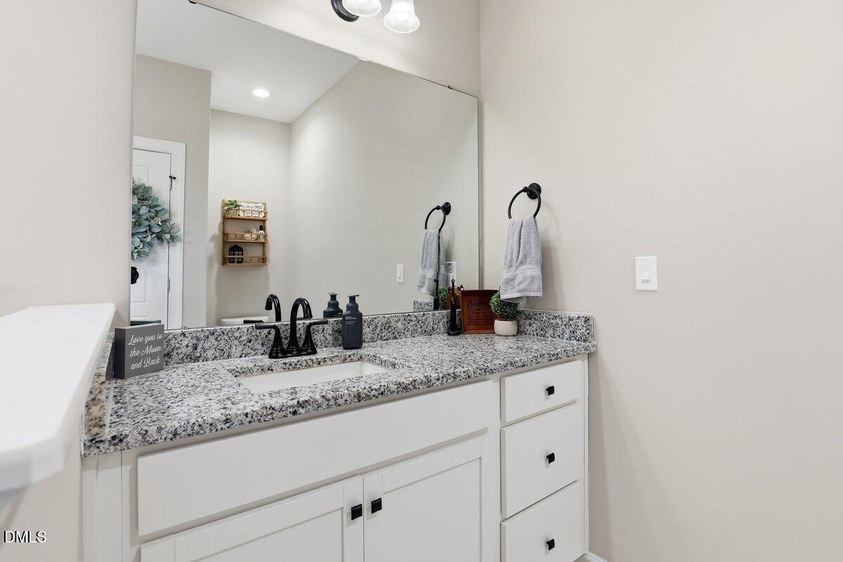 110 Oak Street Pine Level, NC 27568 - Photo 22 of 30 a bathroom with a granite countertop sink and a mirror