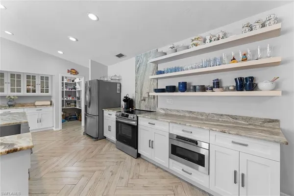 a large kitchen with stainless steel appliances granite countertop a sink and a stove