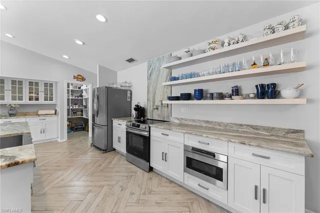 a large kitchen with stainless steel appliances granite countertop a sink and a stove