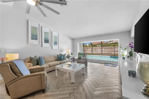 a living room with furniture and a dining table with kitchen view