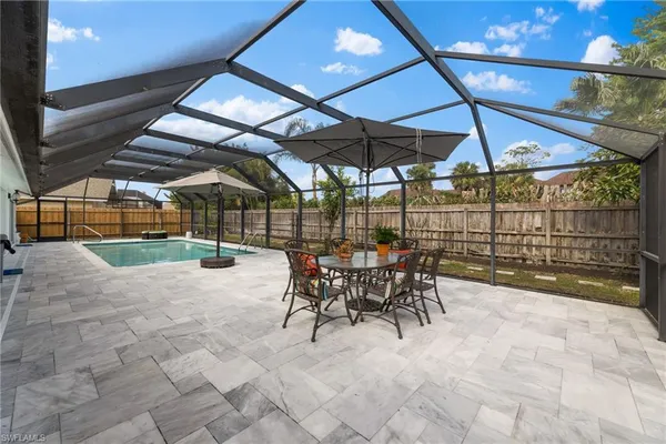 a view of a patio with a table and chairs under an umbrella