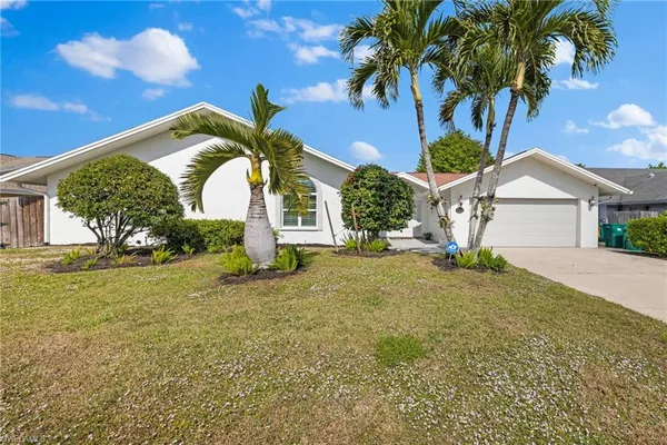 a view of a house with a yard and a garage