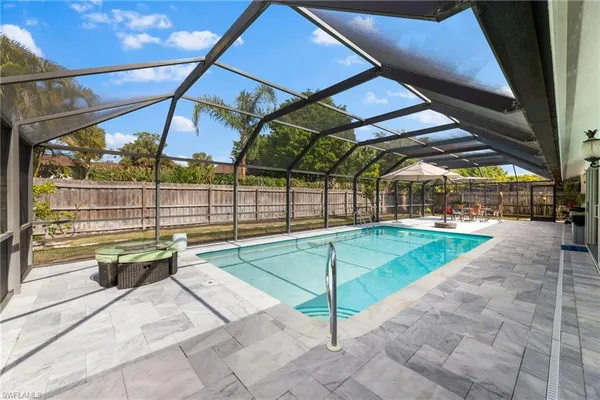 a view of a patio with a table and chairs under an umbrella