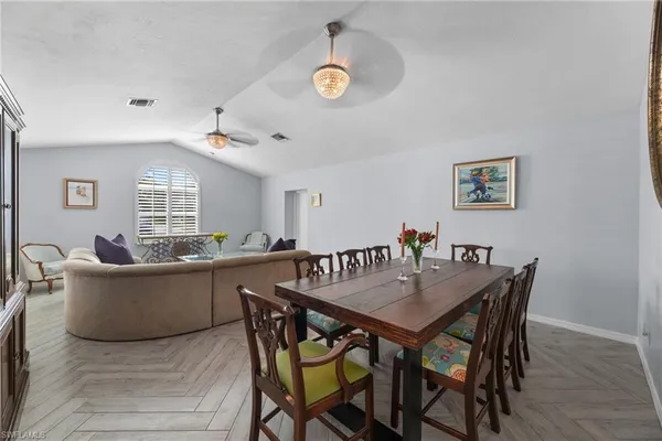 a living room with furniture a rug potted plant and a window