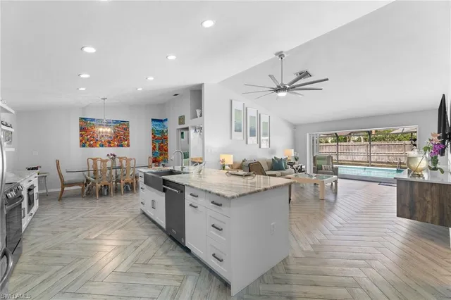 a large kitchen with stainless steel appliances kitchen island a large counter top a stove a refrigerator and a sink