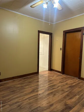 a view of an empty room with a chandelier fan
