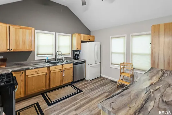 a kitchen with a counter top space a sink stainless steel appliances and cabinets