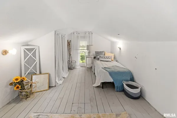 a view of a bedroom with bed and window