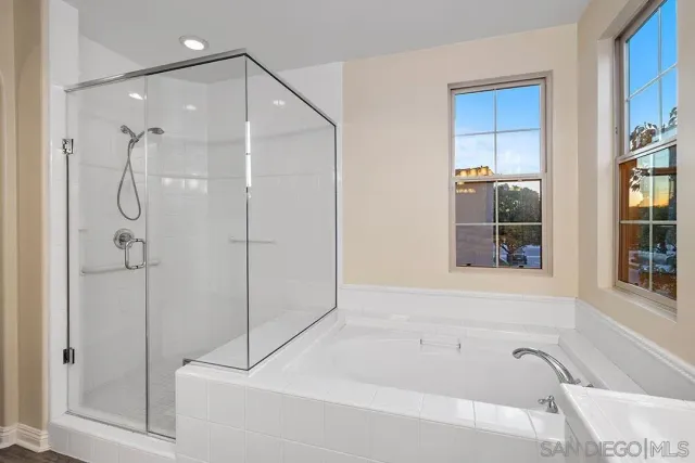 a view of a room with wooden floor fan and windows