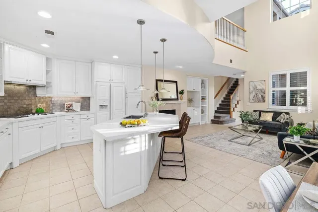 a kitchen with stainless steel appliances kitchen island granite countertop a table chairs sink and cabinets