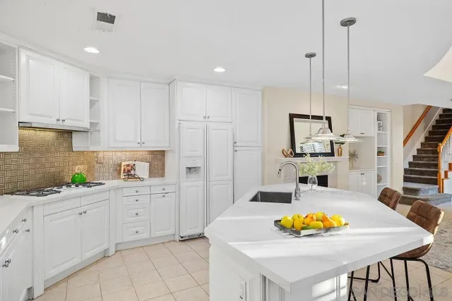 a kitchen with stainless steel appliances granite countertop a sink a stove and refrigerator