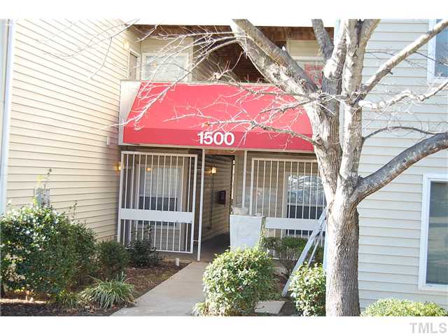 1500 Graduate Lane, Unit 104 Raleigh, NC 27606 - Photo 1 of 15 a view of a house with a small yard and wooden fence