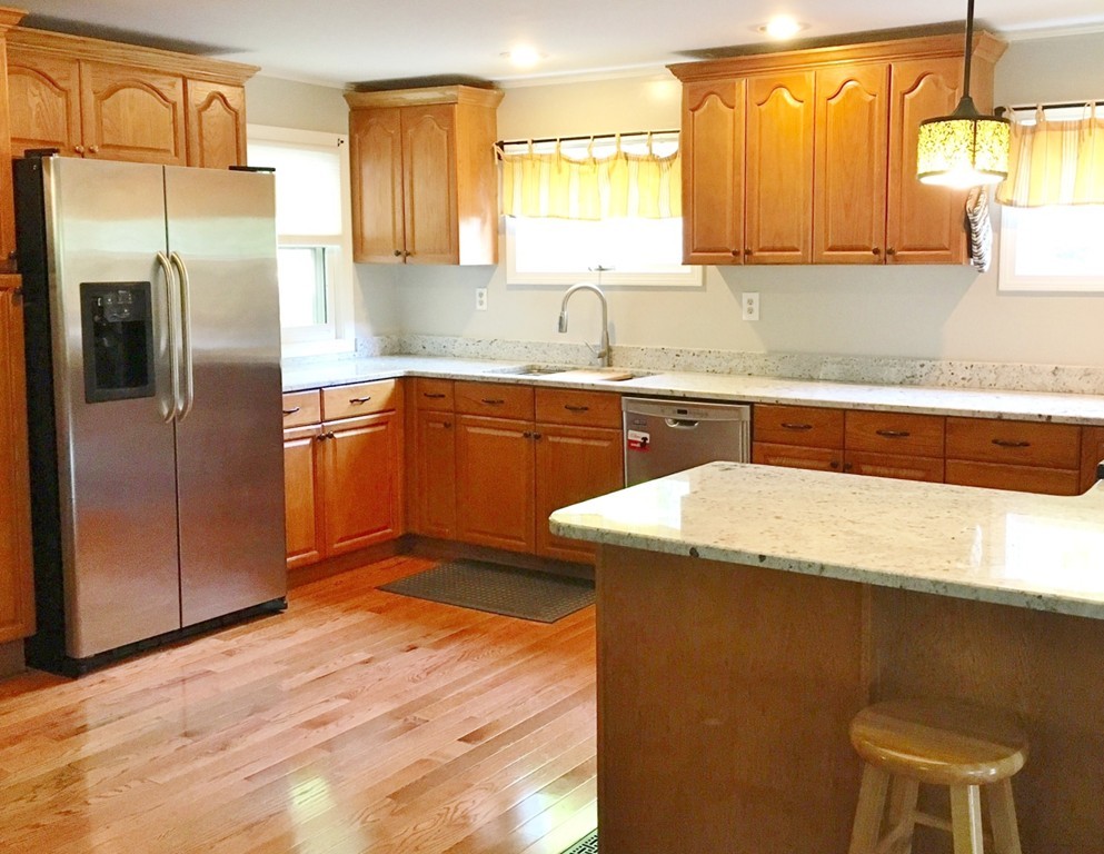 2 Stony Hill Road Holland, MA 01521 - Photo 6 of 24 a kitchen with stainless steel appliances granite countertop a sink a refrigerator and wooden cabinets