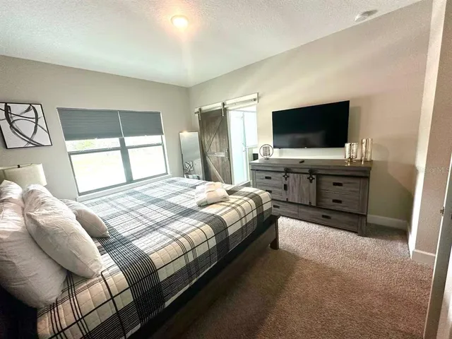 a bedroom with a bed and a flat screen tv